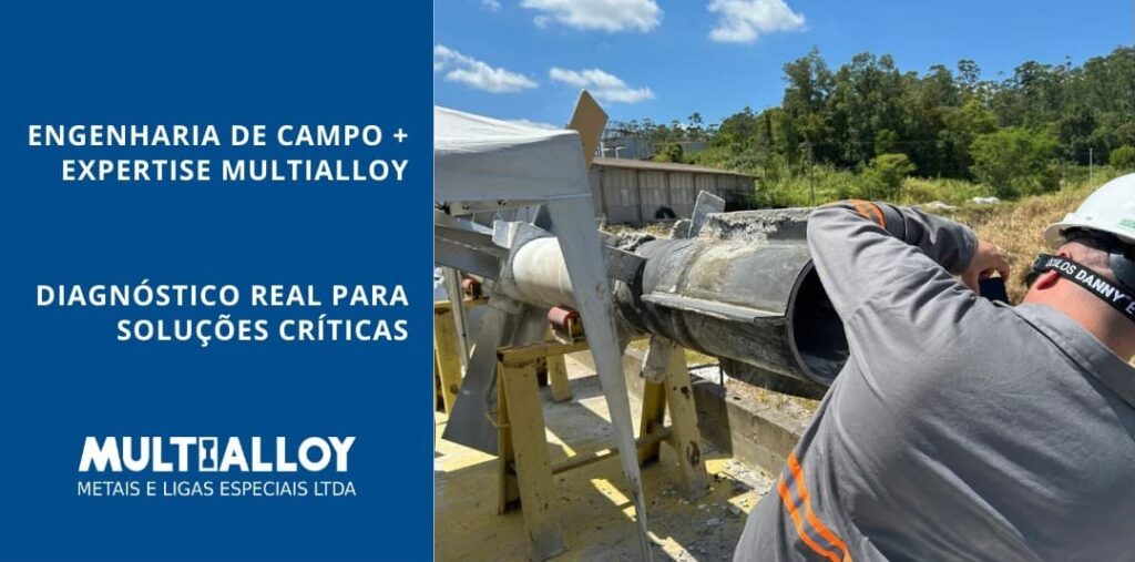 Engenheiro da Multialloy realizando inspeção visual e registro fotográfico da seção interna de um eixo tubular de agitador industrial em campo.